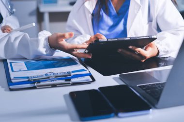 Tıbbi ekip toplantısı, brifing sırasında not alan doktorlar.