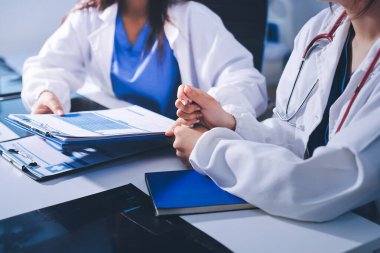 Tıbbi ekip toplantısı, brifing sırasında not alan doktorlar.