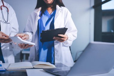 Tıbbi ekip toplantısı, brifing sırasında not alan doktorlar.