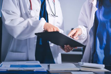 Tıbbi ekip toplantısı, brifing sırasında not alan doktorlar.