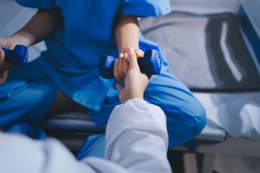 Fizyoterapist esneme egzersizleri yapıyor elastik egzersiz bantları ve fizyoterapist elleri erkek hasta fizik tedavi konseptine yardım ediyor.