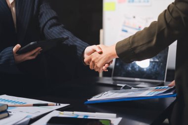 Genç iş adamları ofiste el sıkışıyor. Başarılı toplantı sona eriyor. Üç kişi. Geniş ekran panoramik