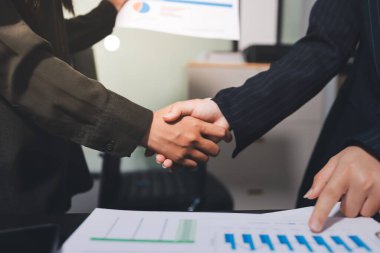 Genç iş adamları ofiste el sıkışıyor. Başarılı toplantı sona eriyor. Üç kişi. Geniş ekran panoramik