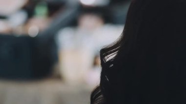 Kadın kuaför, kuaförde esmer saçlı genç bir kadına saç stili yapıyor..