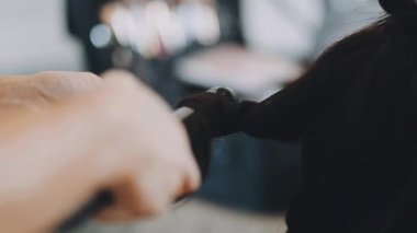 Kadın kuaför, kuaförde esmer saçlı genç bir kadına saç stili yapıyor..