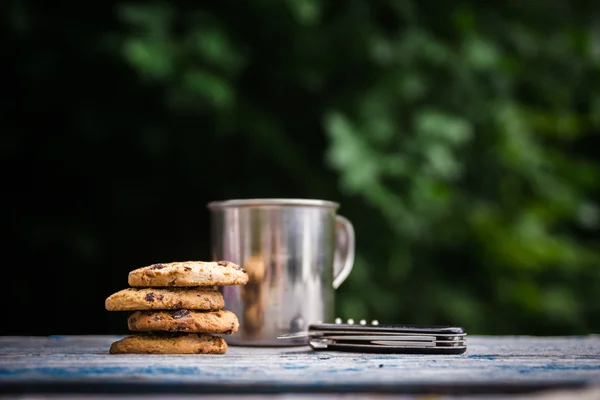 Kekse, Touristen Metallbecher auf einem Tisch im Freien — Stockfoto