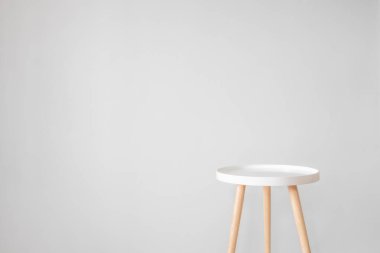 Gri duvarın önündeki boş beyaz kahve masası. İskandinav tarzı, evde minimalizm, sakin yaşam, arka plan ve reklam ve nesne yerleştirme alanı