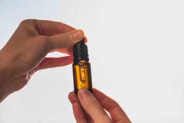 Bir şişe cbd ya da insan eliyle mavi gökyüzüne vurulan THD yağı. Temel petrol, doğal sağlık ürünleri, sakinleştirici takviyeler