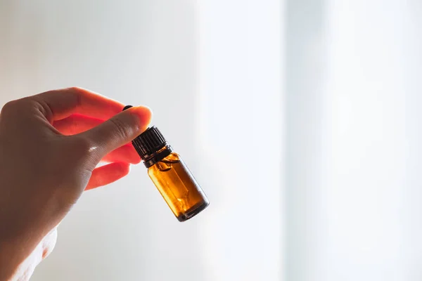 Bottle of cbd or thd oil in human hand. Essential oil, natural health products, calming supplements