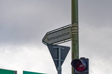 Flensburg 'dan Technologie Zentrum' a kadar bir yol bulma noktası, yakındaki bir trafik ışığı kavşağı izliyor, harf rehberleri ve yürüyenler yoğun köşeden kolaylıkla geçiyor.