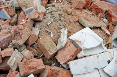 Kırık zemine dökülen tuğla yığını, her tuğla kirlenmiş ve yıkılmış görünüyor. Yıkıldıktan sonra inşaat atığı gibi. Ve küçük külüstür boş bir köşede tek başına oturuyor..