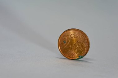 Pürüzsüz bir yüzeyde dik duran iki euro sent para. Küçük para değeri, mikro tasarruf ve mali eğitim kavramları için temiz asgari imaj ideali.