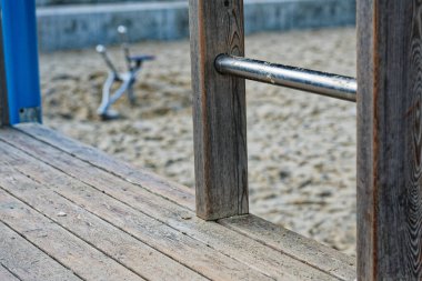 Plajda oturan bir kazıcı, küçük ellerin temiz kuma daldırmak için iki kolu çekmesine izin verir. Yumuşak sörf ve açık gökyüzü, sağlam çerçevenin yanında düzgün siperler oluşurken sakin bir ortam oluşturur..