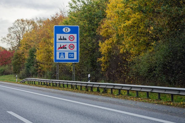 Almanya sınırındaki Alman tarafında trafik yönetmelikleri işareti ulusal hız limitlerini ve sınır ötesi seyahat ve geçişi simgeliyor