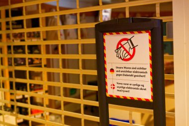 Bir Sylt adası feribotunda metal güvenlik ızgarası hareket eden parçaları, Almanca ve Danimarkaca sarı çıkartmaları ve ellerin şebekenin arkasındaki tehlikeli makineden uzak durması gerektiği uyarısını gizler..