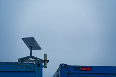 Uzak çalışma dijital altyapısı ve modern bağlantı kavramları için mobil yüksek hızlı internet sağlayan mavi bir konteynır üzerine kurulmuş Starlink uydu anteni