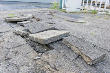 Ağır beton levhalar kırık ve şeritten karşıya kaymış, parçalar birbiri üzerine yığılmış ve yolu tıkamış, bu yüzden her araba yavaşlayıp etraflarından dolaşmak zorunda..