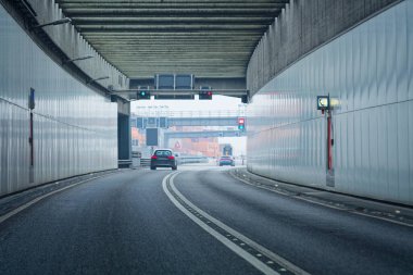 Hamburg Almanya 'sı yakınlarındaki modern bir otoyol tünelinde hızlı hareket eden arabalar, hareketlilik, altyapı lojistik ve kentsel ulaşım kavramlarını sembolize ediyor.