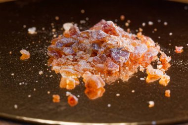 Kahverengi kaya şekeri kristalleri sıcak altın ışıkta parlıyordu. Lüks yemek markaları, kaliteli kafe kavramları ve zarif mutfak dokuları için mükemmel..