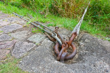 Betona gömülü metal bir halka, metal kablolu üç karabinayı destekleyen daha büyük bir halka barındırır. Donanım gerilim hatları veya ekipmanlar için güvenli bir düzeltme noktası öneriyor.