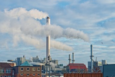 Fabrika binaları Stadtwerke Flensburg. Birden fazla bacası var. Gökyüzüne beyaz duman salıyor..