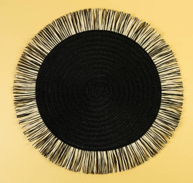 Sarı arkaplandaki siyah hasır masa örtüsünün üst görüntüsü. Saman yuvarlak tepsi, düz konum, kopyalama alanı. 