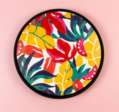 Pembe arka planda siyah tepsi ve renkli tabloların üst görüntüsü. Egzotik bitki plakası, yaz pikniği. Düz yat, boşluğu kopyala.