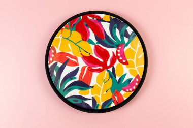 Pembe arka planda siyah tepsi ve renkli tabloların üst görüntüsü. Egzotik bitki plakası, yaz pikniği. Düz yat, boşluğu kopyala.