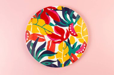 Pembe arka planda renkli plakanın üst görüntüsü. Egzotik bitki plakası, yaz pikniği. Düz yat, boşluğu kopyala.