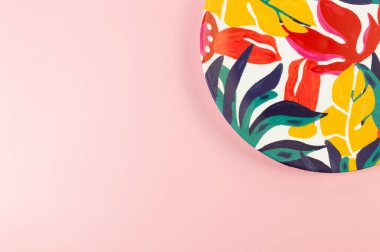 Pembe arka planda renkli plakanın üst görüntüsü. Egzotik bitki plakası, yaz pikniği. Düz yat, boşluğu kopyala.
