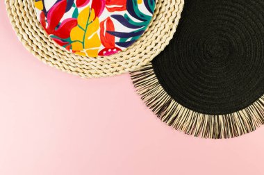 Kahverengi hasır masa paspası, siyah tepsi, pembe arka planda renkli plaka. Saman tepsisi, egzotik bitki tabağı, yaz pikniği. Düz yat, boşluğu kopyala.