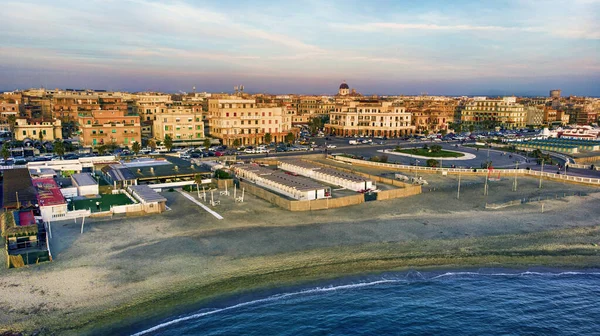 Sunset Rome aerial view in Ostia Lido beach over blue satin sea with city skyline and view of Ravennati square and glimpse of pedestrian pier a landmark of tourist and city life