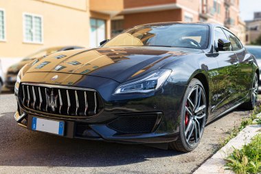 Roma, İtalya - 06 Mayıs 2021: Hızlı ve lüks İtalyan Sedan otomobili Maserati Quattroporte 'nin mavi lacivert üretimi Maserati otomotiv tarafından sokağa park edilmiş şık ve modern ön görüntüsü.