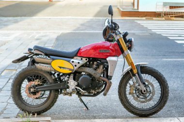 Carloforte, İtalya - 19 Haziran 2021: Off-road motokros motosiklet modeli Caballero Scrambler 500 'ün kırmızı ve sarı renkli güzel tasarımı ve profili.
