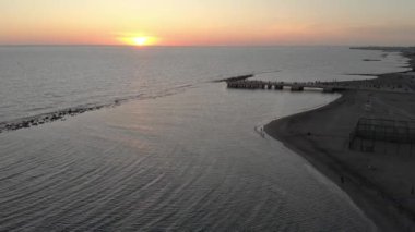 Roma sahilinin yukarısında, ipeksi dalgalı su denizi ve şehrin ufuk çizgisi ve fantastik altın gökyüzü ve güneş alacakaranlığı ufuktaki su denizini vurdu.