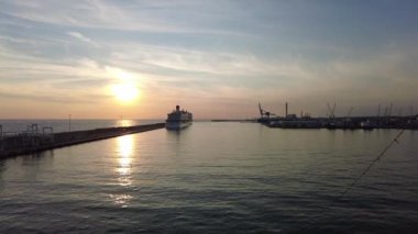Pov yolcu gemisi limandan ayrılıyor. Gün batımı gökyüzü ve iskele ufuk çizgisi harika.