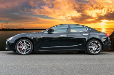Roma, İtalya - 06 Mayıs 2021: Hızlı ve lüks İtalyan sedan arabası Maserati Ghibli 'nin güzel modern tasarımıyla Maserati otomotiv tarafından üretilen ve manzaralı bir arka planda yer alan güçlü ve zarif