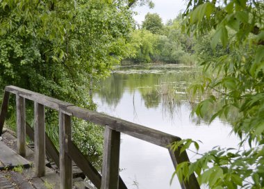 Renkli arka planda nehrin üzerinde güzel duran ahşap bir köprü. Fotoğraf, nehrin yukarısındaki eski ahşap köprüden oluşuyor. Doğal park için nehirdeki eski ahşap köprü..