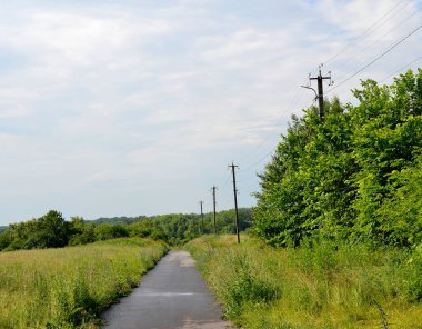 Renkli arka planda, kırsal alanda güzel boş asfalt yol. Fotoğrafçılık, kırsal kesimden geçen yeni boş asfalt yolu içeriyor. Yeşillik kırsalında hız aracı için boş asfalt yol