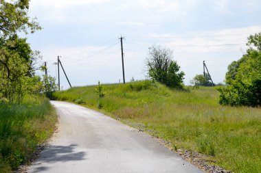 Renkli arka planda, kırsal alanda güzel boş asfalt yol. Fotoğrafçılık, kırsal kesimden geçen yeni boş asfalt yolu içeriyor. Yeşillik kırsalında hız aracı için boş asfalt yol