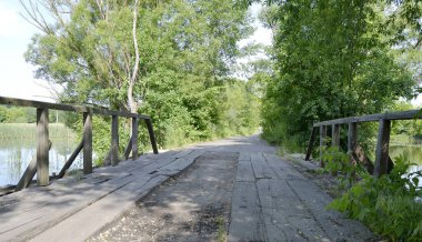 Renkli arka planda nehrin üzerinde güzel duran ahşap bir köprü. Fotoğraf, nehrin yukarısındaki eski ahşap köprüden oluşuyor. Doğal park için nehirdeki eski ahşap köprü..