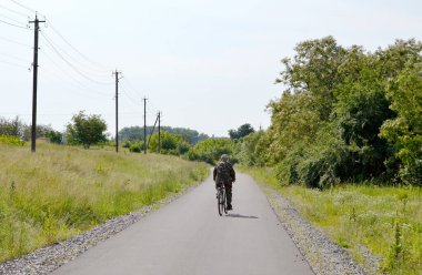 Renkli arka planda, kırsal alanda güzel boş asfalt yol. Fotoğrafçılık, kırsal kesimden geçen yeni boş asfalt yolu içeriyor. Yeşillik kırsalında hız aracı için boş asfalt yol