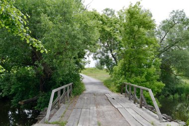 Renkli arka planda nehrin üzerinde güzel duran ahşap bir köprü. Fotoğraf, nehrin yukarısındaki eski ahşap köprüden oluşuyor. Doğal park için nehirdeki eski ahşap köprü..