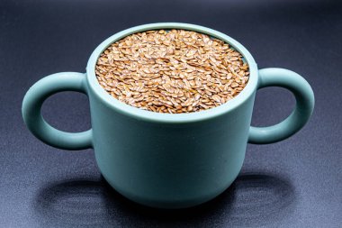 Market tezgahında pek çok lezzetli keten tohumu, taze çiğ keten tohumlarından oluşan lezzetli organik yiyecekler, yakından, arka planda doğal keten tohumlarından oluşan güzel bir doku.