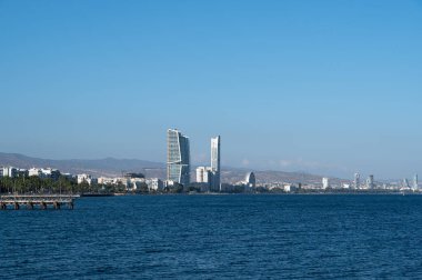 Rıhtım boyunca güzel dizayn edilmiş binalarıyla göz kamaştırıcı bir şehir silueti, hepsi açık mavi gökyüzünün altında