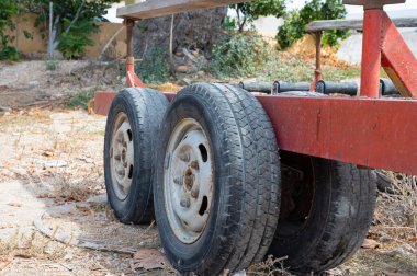 A close-up of a rustic trailer showing weathered tires, representing vintage charm and outdoor landscapes.