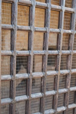 Yıpranmış ahşap kafes penceresi kare şablon desenli, kırsal antika kapı detayı desenli kereste ve ezmeli.