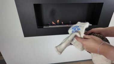 El yapımı yün çorapları nazik iç ısı kaynağının etrafına saran eller.
