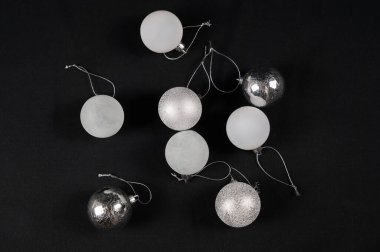 Siyah arkaplanda gümüş ve beyaz süsler, parıltı ve mat dokular, yansıtıcı küreler, minimalist lüks tatilleri yakalayan stüdyo dairesi.