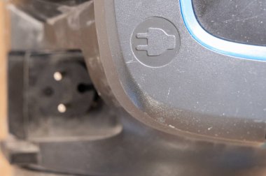 vakum güç girişi tıkaçları gösteriyor, çatallar sokete sıkıştırılmış, toz konnektör etrafında, güvenlik simgesi kabartmalı, kablo gerginliği giderici ve aşınmış, güç aşınması